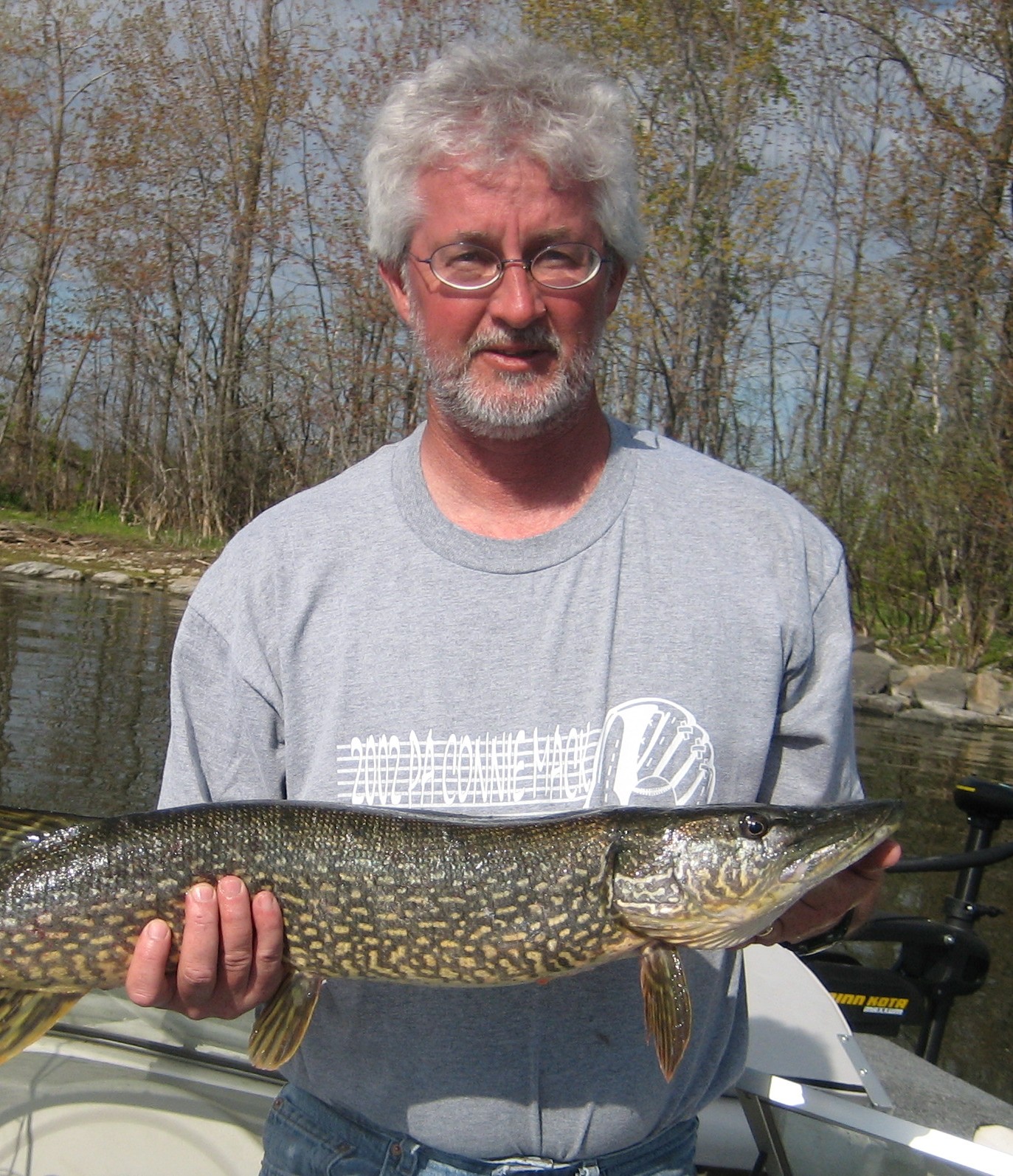 An angler holding a northern pike on a Fish N Tales outing